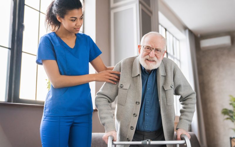 handicapped-man-using-walker-rehabilitation-at-home-nurse-helping-disabled-man-using-walker.jpg